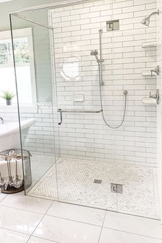 a bathroom with a walk in shower next to a bathtub and sink under a window