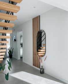 a modern staircase with wooden handrails and metal railing, leading to the upper floor