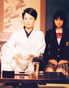 two women in kimonos sitting at a table