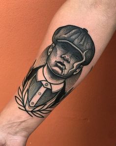 a man's arm with a black and white portrait tattoo on the left forearm