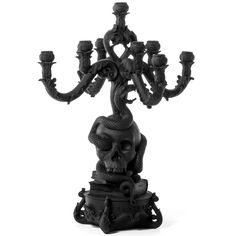 a black and white photo of a candle holder with a skull on it's head