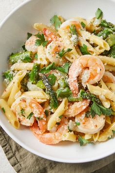 pasta with shrimp, broccoli and parmesan cheese in a white bowl