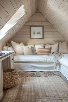 an attic bedroom with white bedding and pillows