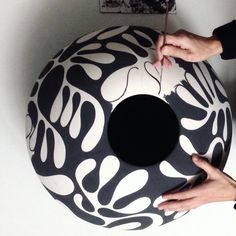 a person is painting a large black and white object