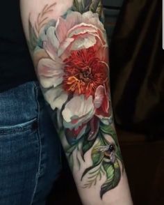 a woman's arm with flowers and leaves painted on the back of her arm