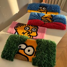 three towels with cartoon characters on them sitting on top of a white table in front of a window