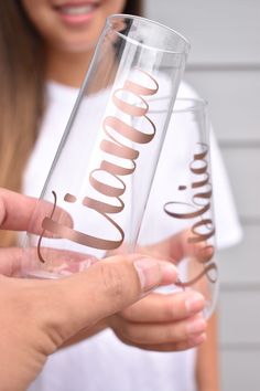 a woman holding two wine glasses with the word london printed on them