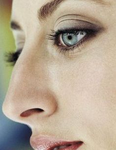 a close up of a woman's face with blue eyes