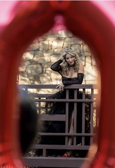 a woman in a black dress sitting on a bench