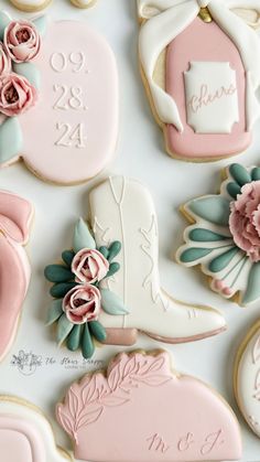 decorated cookies are arranged on a table with pink and blue decorations, including boots, flowers, and lace