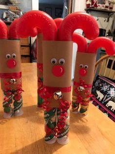 three toilet paper roll christmas decorations sitting on top of a wooden table next to each other