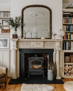 a living room filled with furniture and a fire place in front of a book shelf