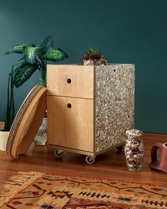 a wooden cabinet sitting on top of a hard wood floor next to a potted plant