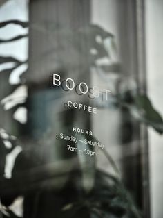 an advertisement for a coffee shop is reflected in the window