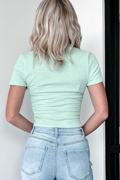 This item is a Doorbuster and NOT Sale Coupon Eligible. 97% POLYESTER, 3% SPANDEX Model Wearing Size Small Color: Mint Crinkled/Smocked Knit Collared V-Neck Button-Front Short Sleeves Fitted Silhouette Cropped Length Top Has Stretch 1.5“ Armpit To Sleeve End 9.5" Armpit To Hemline For Model Size Specs Please Check Size Charts Launched: 7/7/24