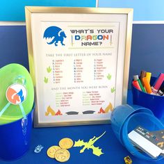 a blue table topped with lots of items and a framed sign that says what's your dragon name