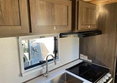 a kitchen area with sink, stove and cabinets