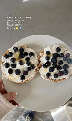 two blueberries and yogurt sandwiches are on a white plate with the words caramel rice cakes