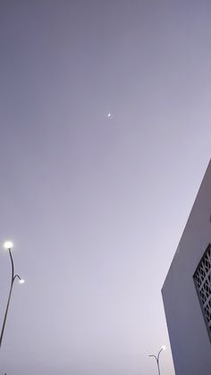 an airplane is flying in the sky over some buildings and street lights on a foggy day