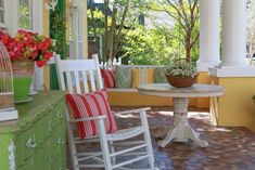 a white rocking chair sitting next to a table