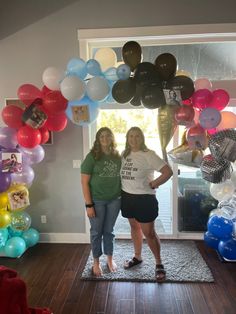 two women standing in front of a doorway with balloons all over the floor and walls