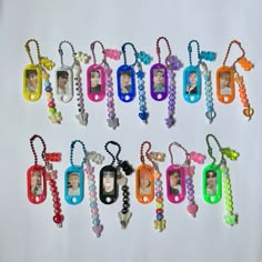 a group of different colored key chains with pictures and beads hanging from each one's sides