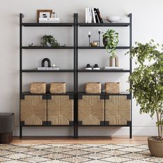 a black bookcase with baskets and plants on it next to a potted plant