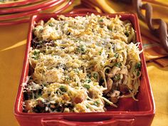 a red casserole dish filled with pasta and vegetables