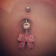 a belly button with a pink bow charm