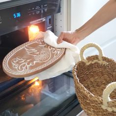 someone is cleaning an oven with a cloth and basket in front of the oven door