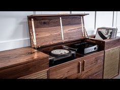 an old record player is sitting on top of a wooden cabinet with its lid open