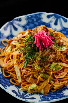 a blue and white plate topped with noodles