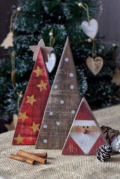 three wooden christmas trees sitting on top of a table