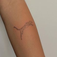 a small tattoo on the arm of a woman's arm, depicting a running dog