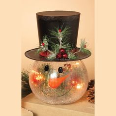 a snowman with a top hat and lights in it's mouth sitting on a table