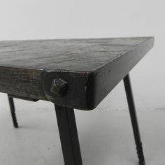 an old wooden table with metal legs and a knob on the top that is missing