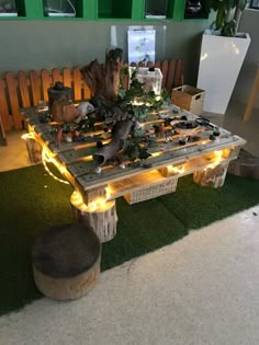 a wooden table with lights on it sitting in the middle of a grass covered floor