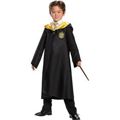 a young boy dressed in a harry potter costume and holding a wand with both hands