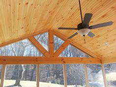 a ceiling fan mounted to the side of a wooden roof