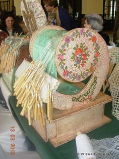 an old fashioned spinning wheel with knitting needles and yarns on display in a store