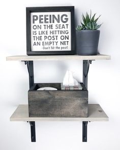 two shelves with some plants on top of them and one shelf has a sign that says peeing on the seat