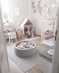 a child's room with pink and white decor, including a dollhouse bed