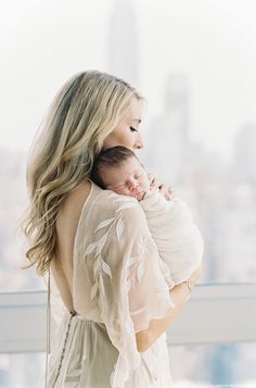 a woman holding a baby in her arms with the caption nested in their hearts