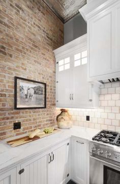 a kitchen with brick walls and white cabinets