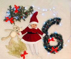 a baby dressed as santa claus is surrounded by christmas decorations