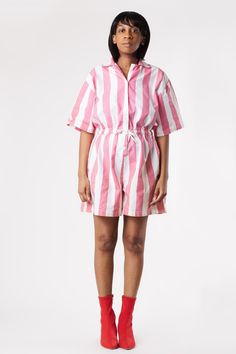 This super cute, vintage 80's pink stripe shorts romper buttons-up, as an elastic waist, and also ties at the waist. Size + Care- Size: S- Chest: 40in- Sleeve Length: 17in- Length: 33in- Waist: 36in (stretched)- Care: Machine Wash Cold- Material: 100% Cotton- Condition: Excellent * Our Model is Size US 2 and 5'6 Tall Pink Retro Jumpsuits And Rompers For Spring, Retro Pink Jumpsuits And Rompers For Summer, Pink Bottoms With Vertical Stripes For Summer, Retro Pink Summer Jumpsuits And Rompers, Pink Vertical Striped Bottoms For Summer, Pink Retro Summer Jumpsuits And Rompers, Summer Pink Bottoms With Vertical Stripes, Pink Vertical Stripes Bottoms For Summer, Striped Short Sleeve Jumpsuits And Rompers For Summer