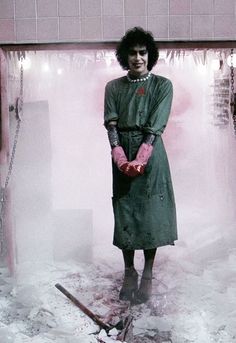 a woman standing in the snow with her hands on her hip and wearing pink gloves