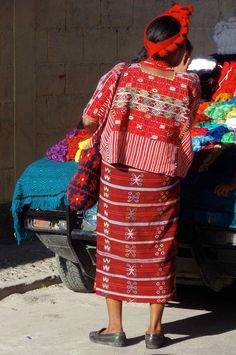 a woman standing in front of a truck loaded with blankets