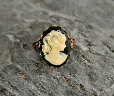 A gorgeous detailed cameo with a black background and cream relief set in detailed antiqued brass. Ring is antiqued brass with an adjustable, detailed band. Details: Ring measures 20mm x 15mm Ring band is adjustable, sizes 6 - 8-1/2 Ring is plated brass Lead & Nickel free Cameo is hard, matte resin Please allow for possible slight color differences due to different settings on different screens. Thank you for shopping Delicate Industry :) Antique Cameo Ring, Vintage Black Cameo Ring, Black Cameo Ring As Gift, Black Cameo Ring For Gift, Victorian Cameo Rings As Gift, Black Cameo, Gift Ideas For Mom, Jewelry Holiday, Unique Christmas Gift