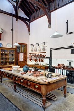 an old fashioned kitchen with many pots and pans